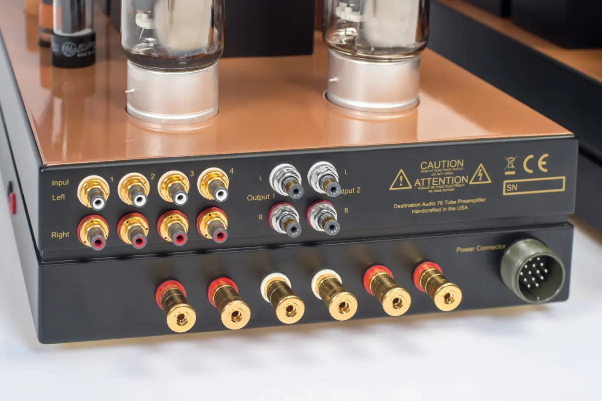 Rear panel of a Destination Audio tube amplifier with brass-colored RCA inputs, outputs and a power connector