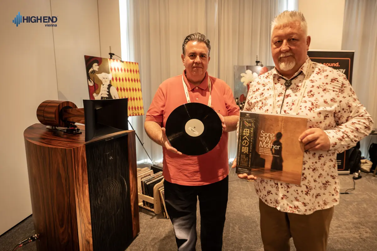 Two men holding a vinyl record and the Song for My Mother album next to a Destination Audio horn speaker