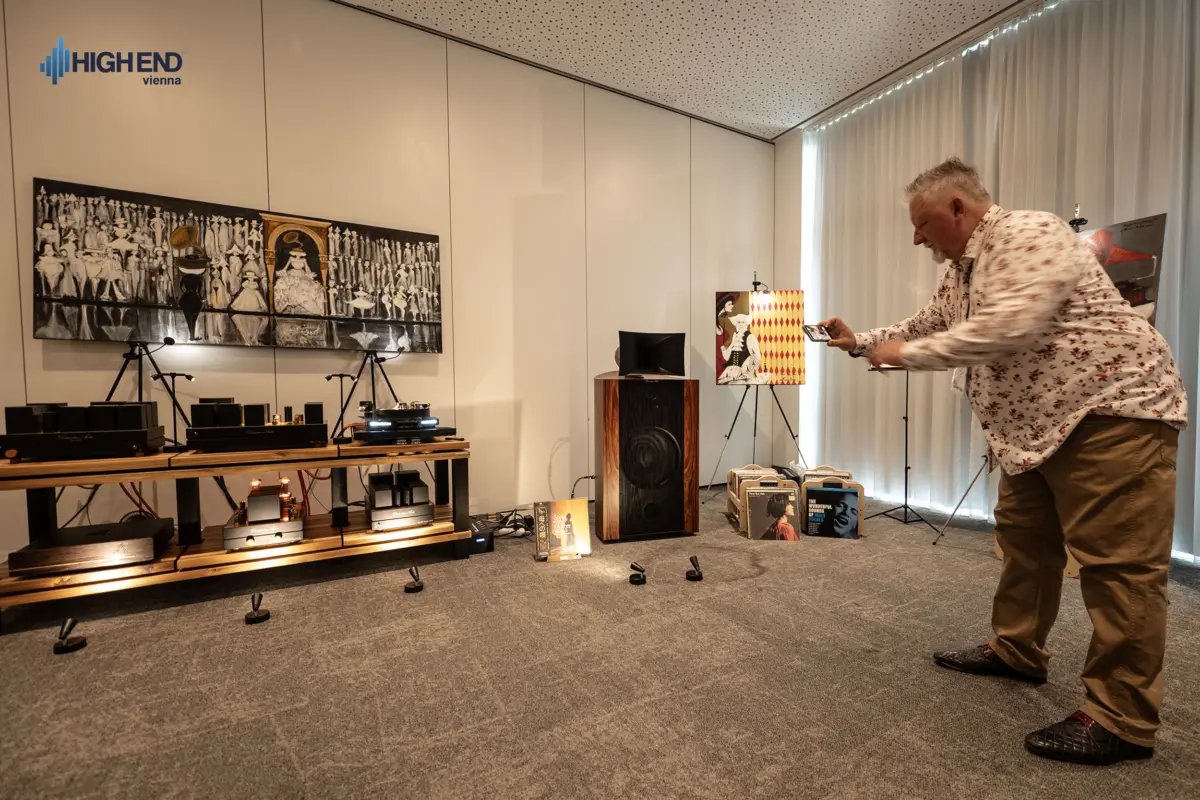 The Destination Audio listening room at High End Vienna with a horn speaker, a rack of tube amplifiers and paintings