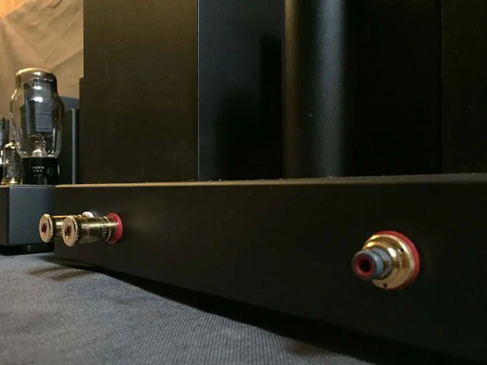 Brass-colored speaker terminal and RCA input on the side of a Destination Audio tube amplifier